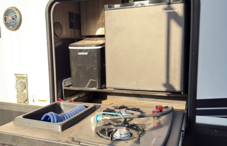 Outdoor Kitchen with ice machine and small refrigerator.