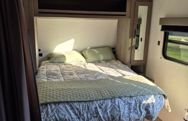 Modern luxury inside! Features a private master queen, double bunks, a huge U-shaped dinette slide-out, a fully loaded kitchen, a 10.2 cu ft fridge, a full bath, and premium JBL sound.