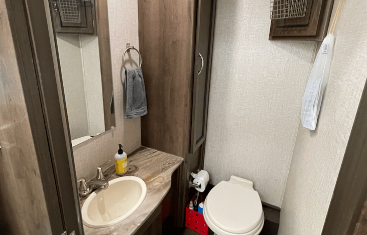 Toilet room with ventilation. A regular sized toilet and good size sink. Cleaning products are available for your use, along with towels and air fresheners. We provide RV safe toilet paper for you.