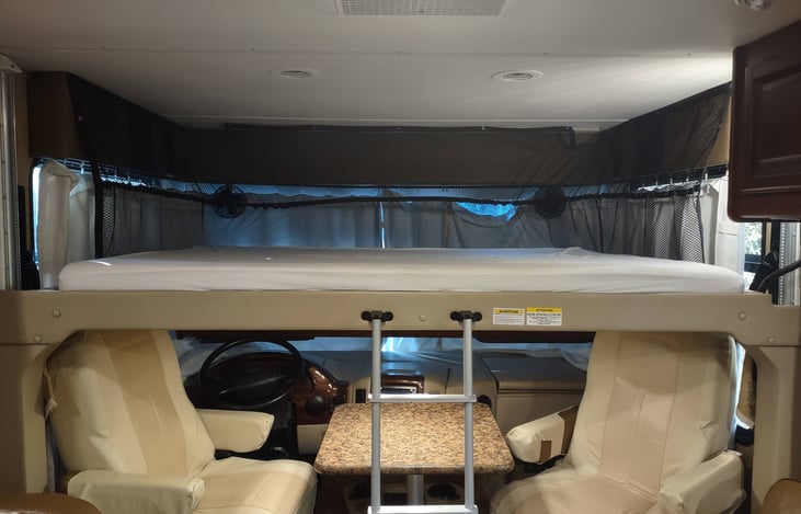 spacious bunk above driving area drops down over lounge