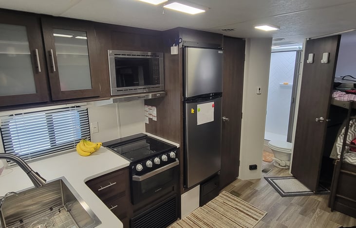 Large fridge and freezer. 3 burner propane stove and oven. Microwave and vent.