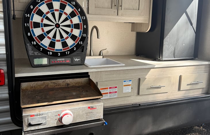 Outdoor Kitchen with flat top grill, sink, and large mini fridge!