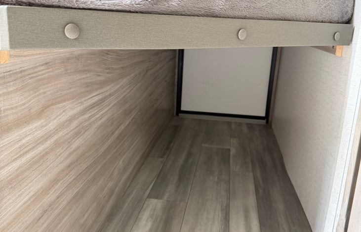 Extra storage beneath bottom bunk that is also accessible from exterior (2nd) door if need be