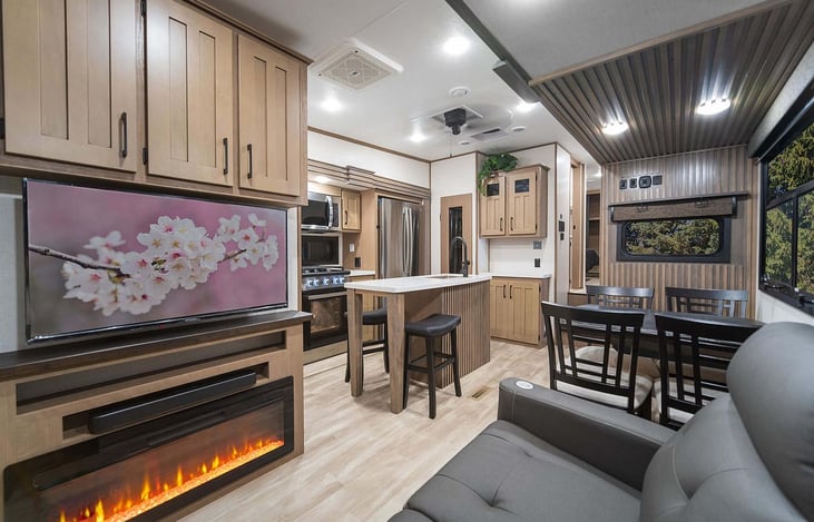 Living area with sofa, TV, fireplace, and dining table.