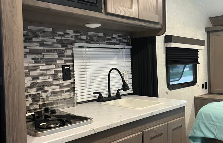 Kitchen area 2 burners Upgraded faucet with sprayer. Microwave refrigerator, freezer and curtain for privacy in the bed area.