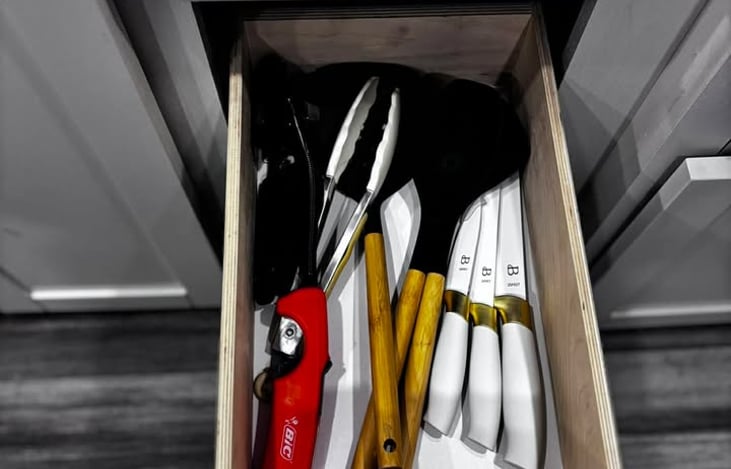 A neatly organized kitchen drawer stocked with quality utensils, giving renters everything they need for easy meal prep.