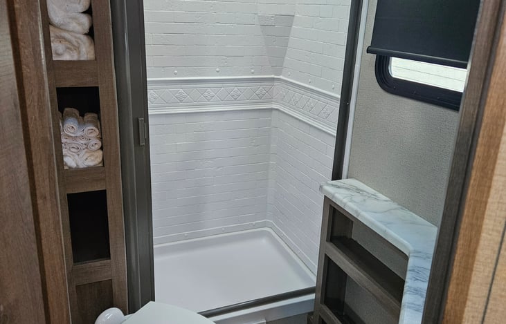 Conveniently laid out bathroom. Shower with retractable door, angled toilet, sink to the right. (we provide towels)