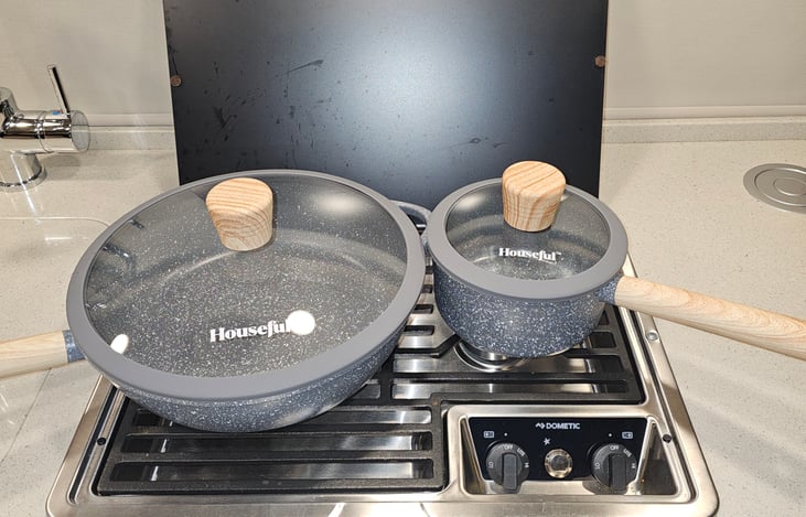 2 burner propane stove shown with large deep fry pan and small sauce pot.