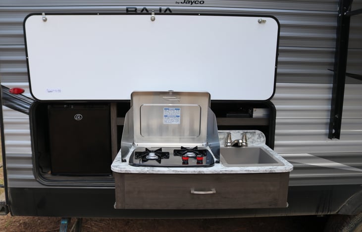Outdoor stove, sink, and mini fridge. There is plumbing to connect your outdoor grill directly to propane as well.