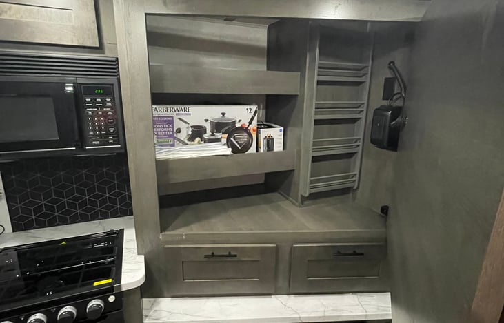 Stocked with pots, pans, toaster, cooking utensils, eating utensils, can opener.