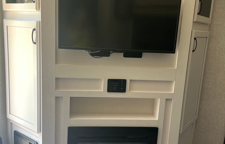 Electric fire place and tv, and a games cabinet stocked with a few fun choices.