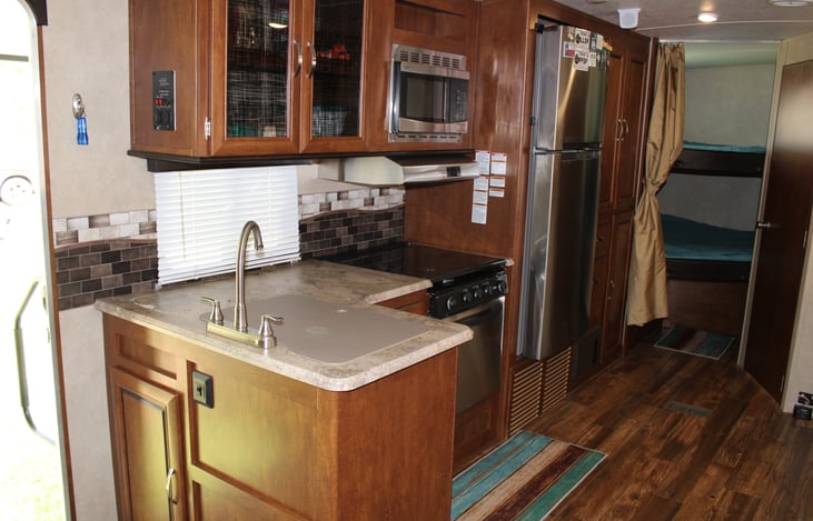 Kitchen area includes all utensils, pots, pans, some snacks, Keurig Coffee Maker, microwave, gas stovetop, oven, refrigerator/freezer.