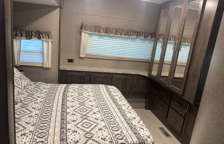 Master bedroom. Queen size bed and tv mounted on the wall.