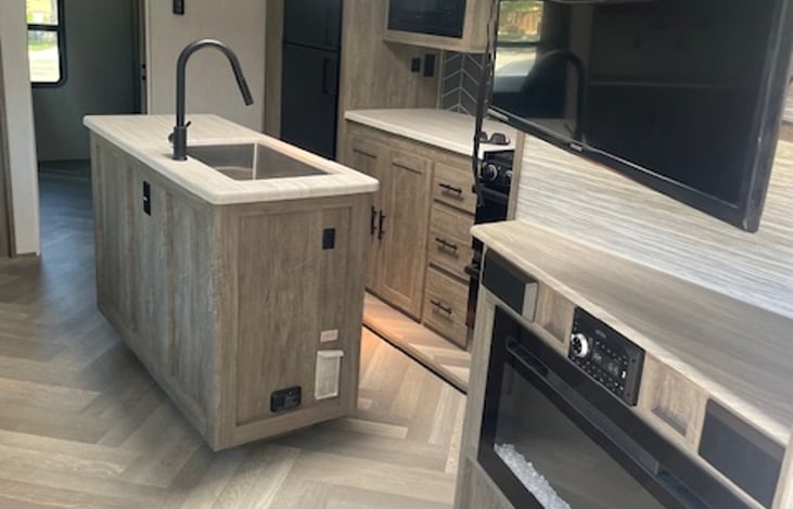 Full kitchen with island, coffee bar with Keurig, and pantry storage.