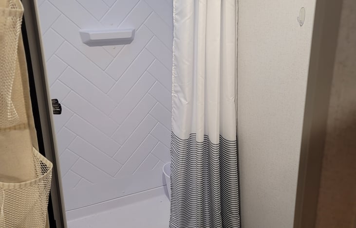 Bathroom with shower, toilet, sink and mirrored  medicine cabinet