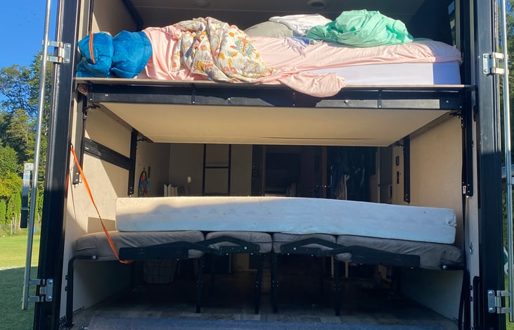 Upper bed lowers, benches fold into another bed