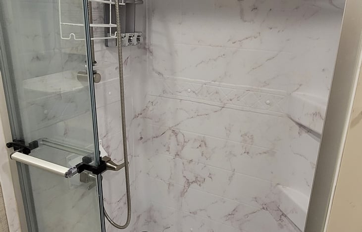 Shower with shampoo/conditioner/body wash dispenser and loofah rack.