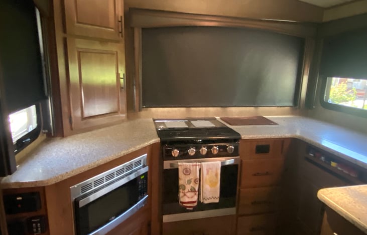 Beautiful kitchen with counter space, microwave stove, spice rack, plenty of drawers stocked with all you might need for a camping stay.