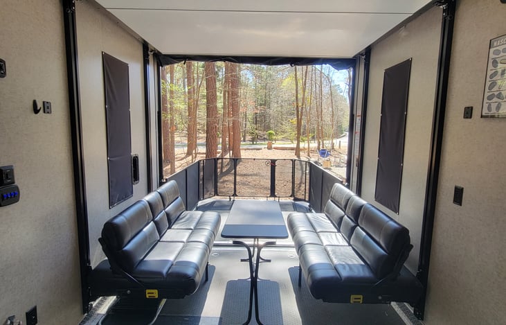 Rear "Garage" area.  Couches shown fold into queen bed.  Another queen bed retracts from ceiling on tracks.  Ramp on back of camper folds down using cables into a elevated porch area.