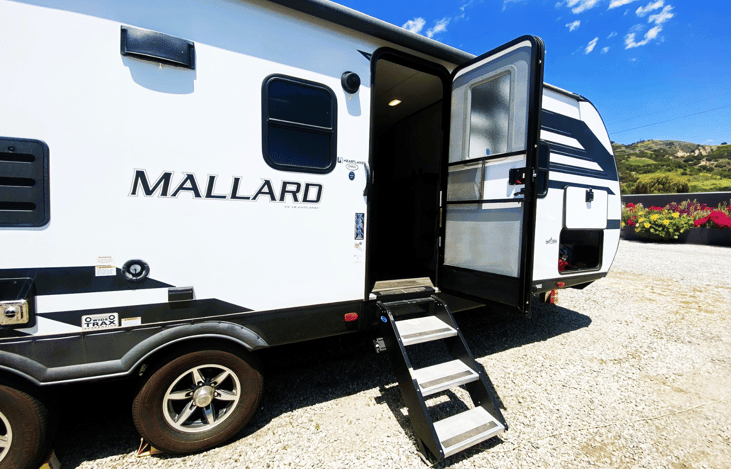 Side view of the Mallard with slide-out extended — ready for delivery to campsites like Zuni Campground, Temecula, or San Onofre. Popular among those looking for RV rent near me with easy setup!