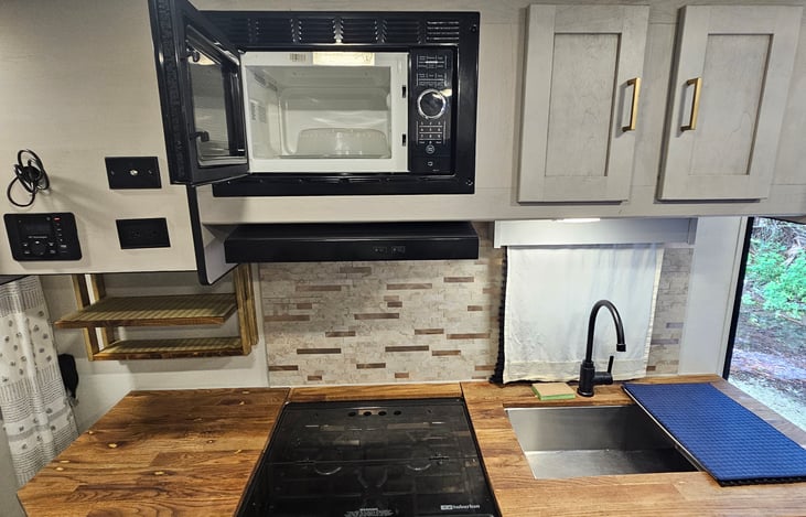 Complete kitchen setup with stovetop, convection oven, and microwave — cook with ease on the go