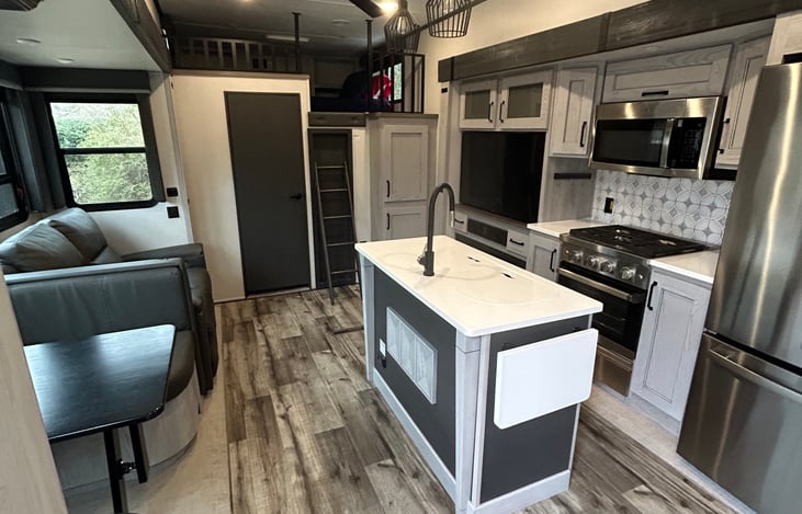 Kitchen feature convertible table top bed, lots of cabinets for storage, a full size fridge, stove/range and microwave.