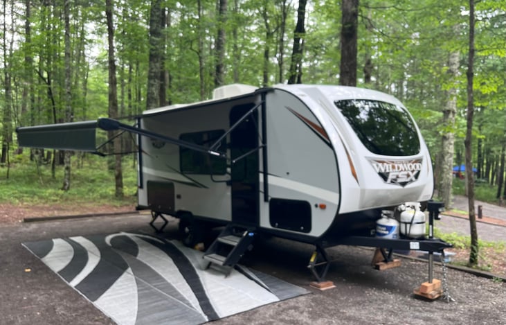 Electric awning with large outdoor vinyl mat.