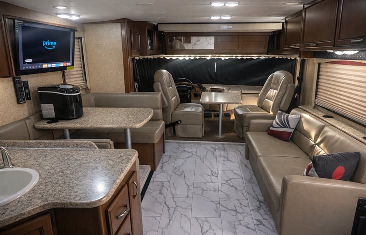 The over-cab bunk, convertible dinette, & pull-out sofa provide plenty of comfortable sleeping space. This area also features 2 captain’s chairs, a table, and a Smart TV for relaxing and entertaining