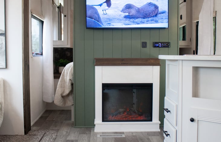 Cozy moments made perfect: Gather around the inviting fireplace in the camper, as the flickering flames create an ambiance of warmth and relaxation.