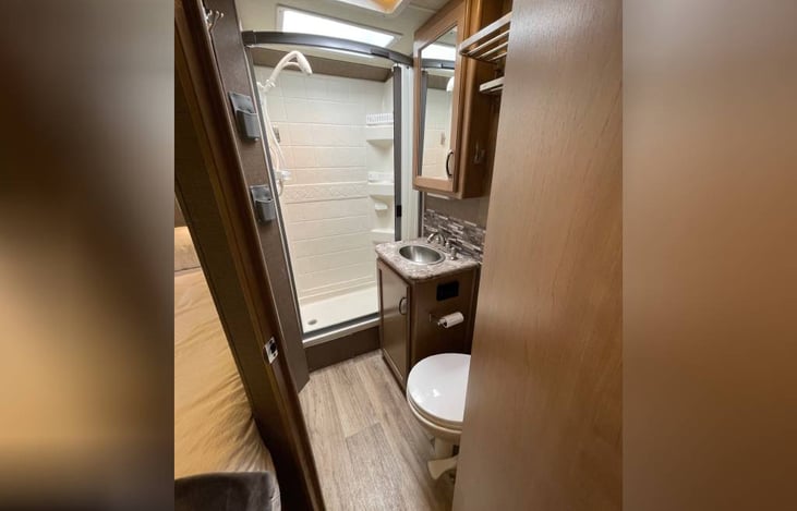 View of Bathroom. Shower has skylight and built in curtain.