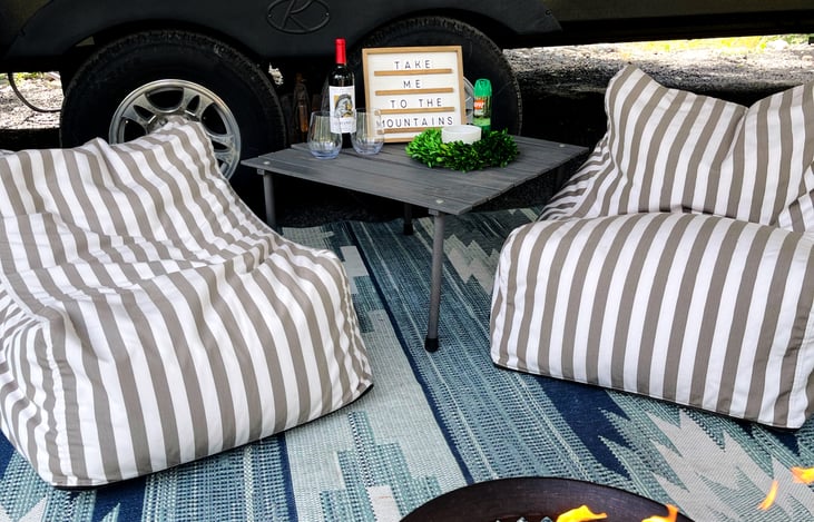 Delivery option comes completely set-up with a large  outdoor rug, bean bag chairs, coffee table, fire pit, and even a customizable letter board ready when you arrive!