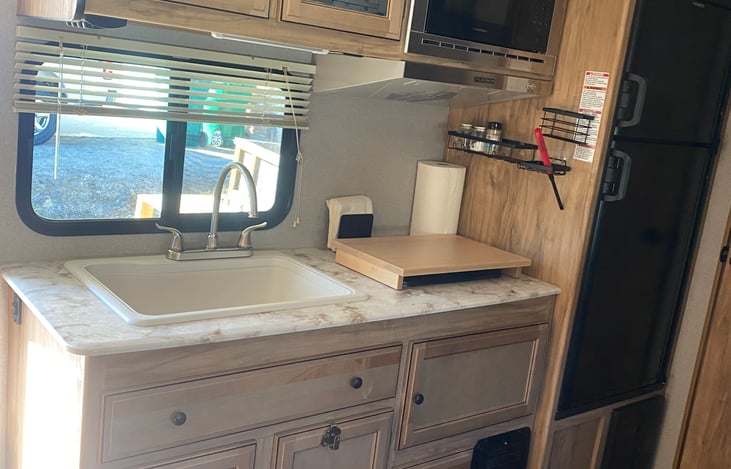 KITCHEN INCLUDES LARGE SINK, MICROWAVE, 2 BURNER COOKTOP AND LOTS OF DRAWERS AND CABINETS FOR STORAGE.