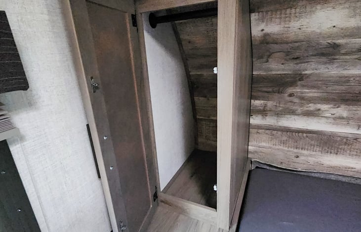 Storage to hang clothes on both sides of queen-sized bed.