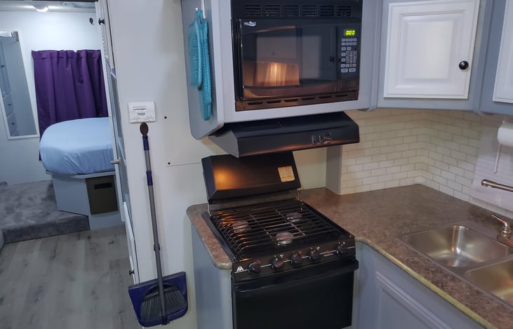 Propane stove and oven with range and microwave above.