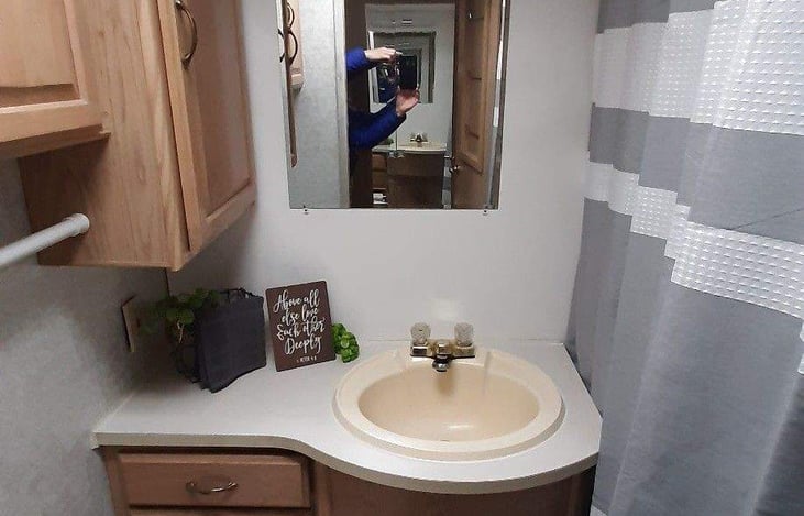 The shower is a camper size shower with sliding doors and shower curtain, there is a good amount of storage and counter space as well!