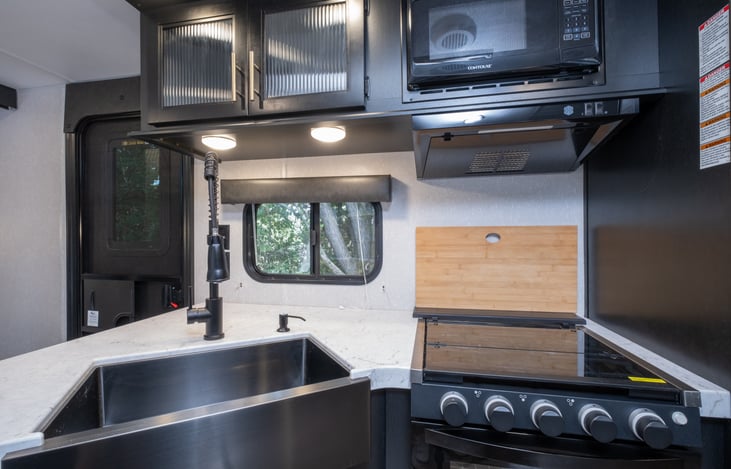 12. Kitchen Close-Up
Cook with ease using the three-burner stove, oven, microwave, deep sink, and generous countertop space in this fully stocked kitchen.