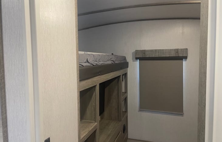 Bunkroom with 3 single beds and TV.