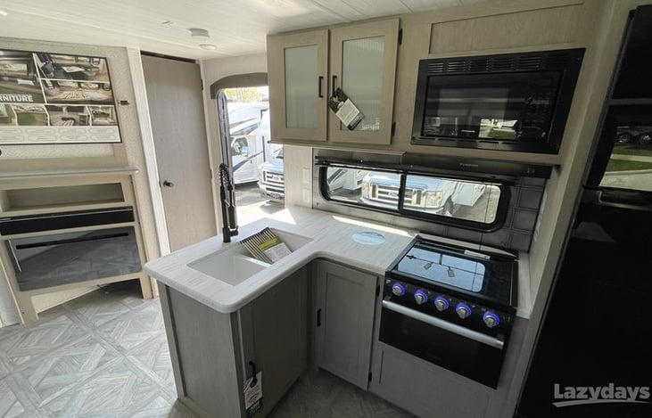 Kitchen with sink, microwave, oven and stove top.