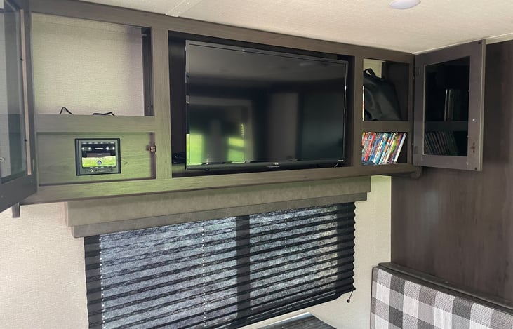 Radio controls to the left, including indoor/outdoor speaker control. DVD player and DVDs to the right. Includes USB cord and 25 family friendly movies.