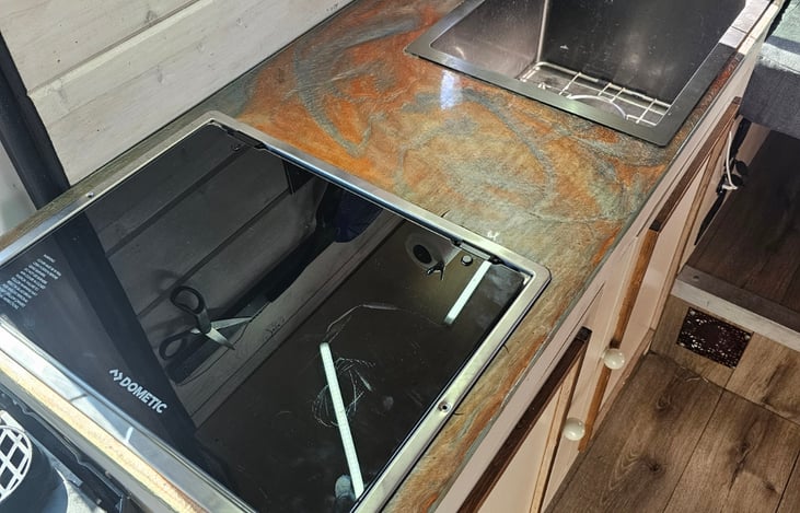 New cooktop has a glass top to lessen noise and give more flat space countertop