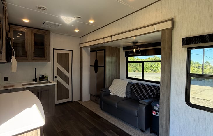 Rustic wood accents, charming farmhouse details, and comfortable seating make this fifth wheel feel like home.