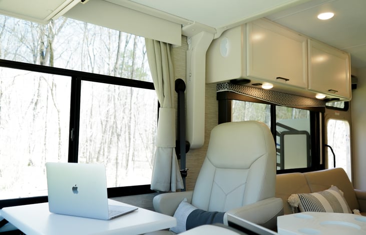 pull down passenger seat has a fold-out desk and electric outlet charging station
