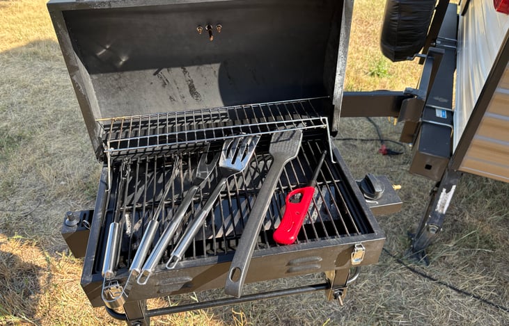 Swing out grill with utensils included.