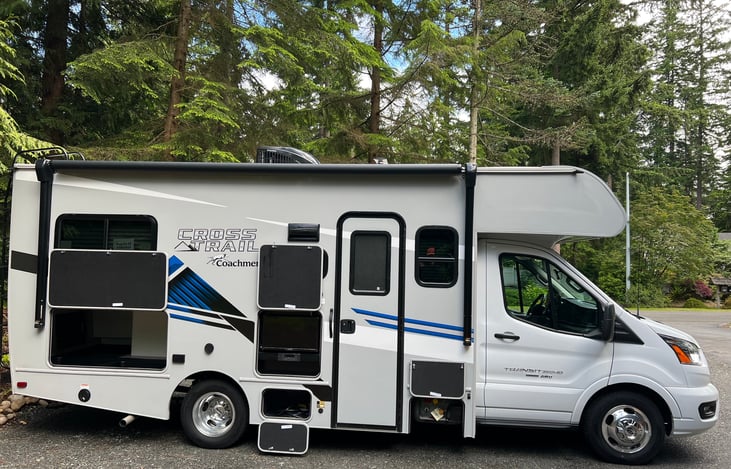 Left side profile with luggage hold, external TV and propane tank exposed.