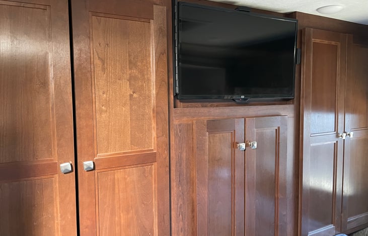 Triple wardrobe with Roku TV in private queen bedroom.