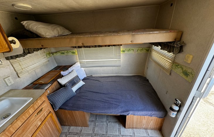 The front area can easily sleep 3 people: 2 in the folded bed where the eating booth is, and the bunk bed above it.