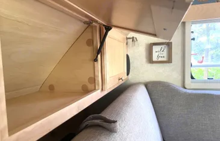 3 overhead storage bins behind sofa and above the head of the bed.