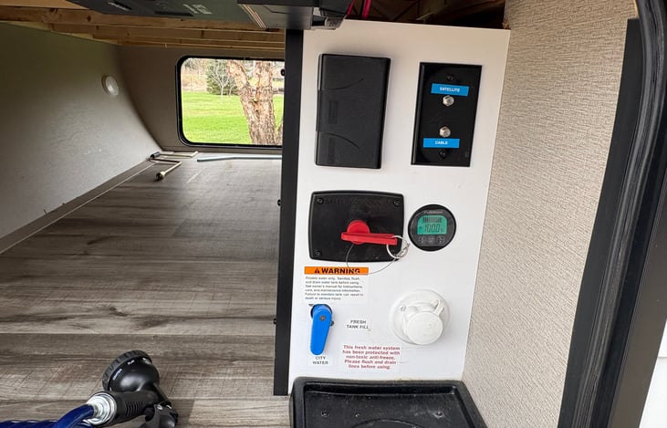 Exterior control center. Power disconnect, water connection, solar panel gauge, antenna and cable hook up and a 120 outlet just in case.