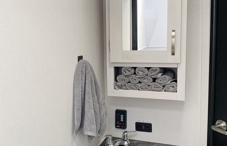 Cabinet above sink has plastic bins to hold your toiletries. Pump switches are located by sink.