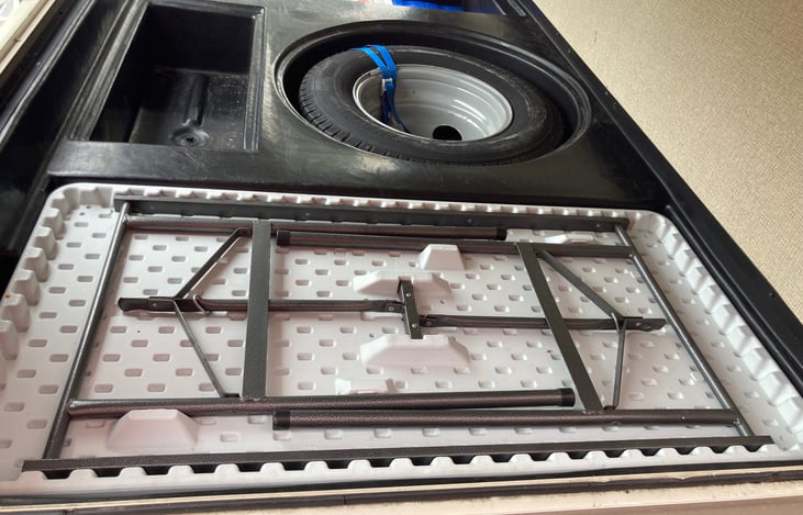 Rear storage fully accessible by 3 outside doors, spare tire & fold out table